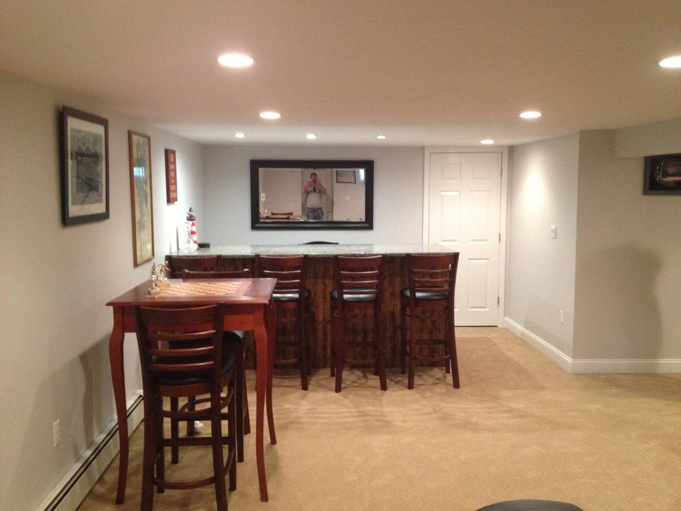 Finished basement bar with stools and cabinetry