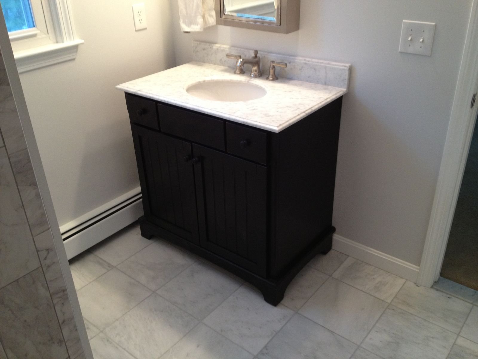 Dark vanity with marble top and tile floor