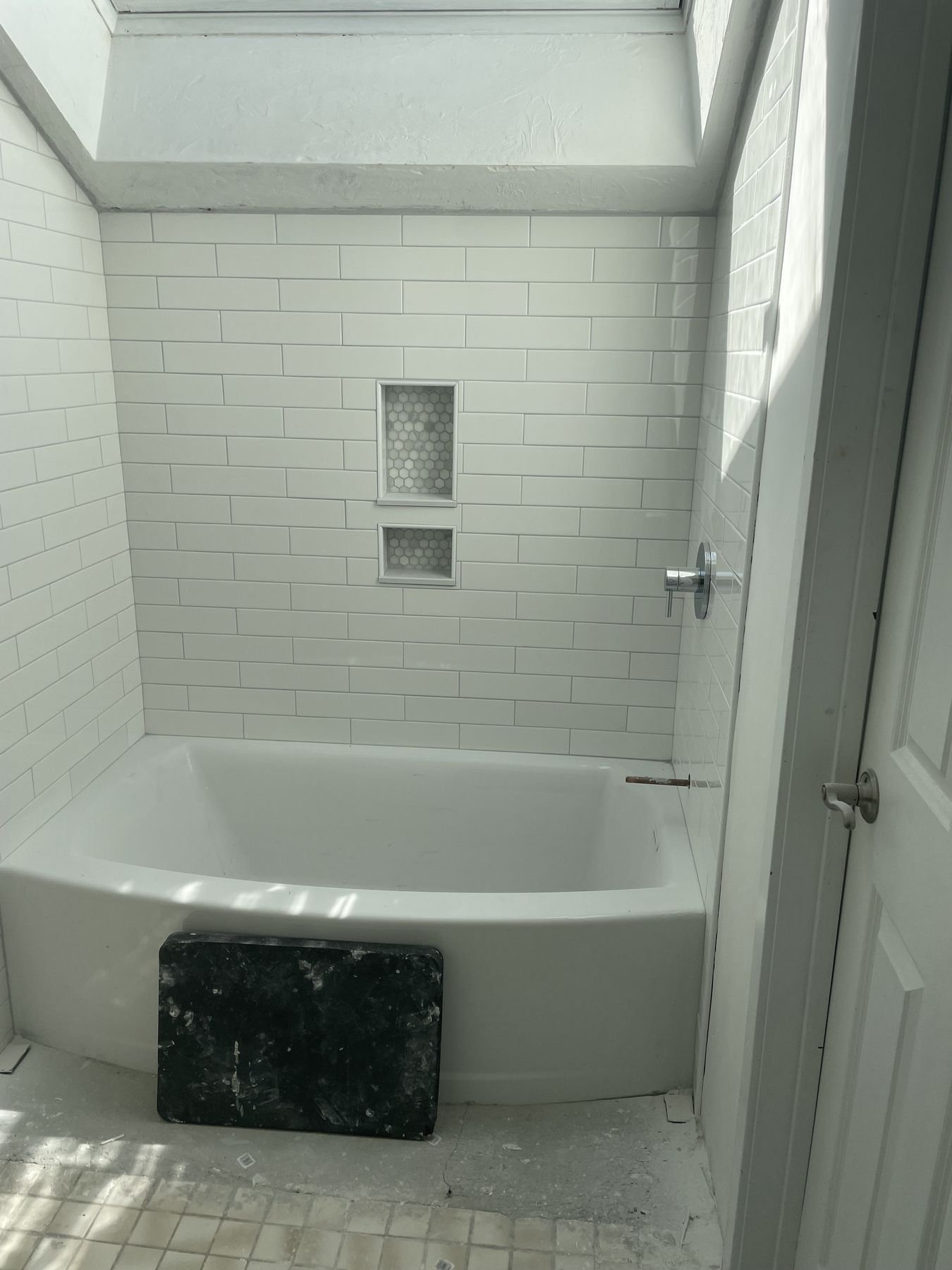 Bathroom with tiled tub surround under a skylight