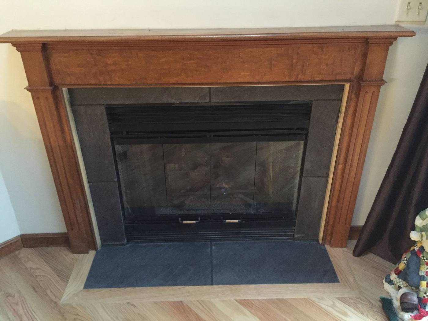 Wood fireplace mantle above new oak flooring