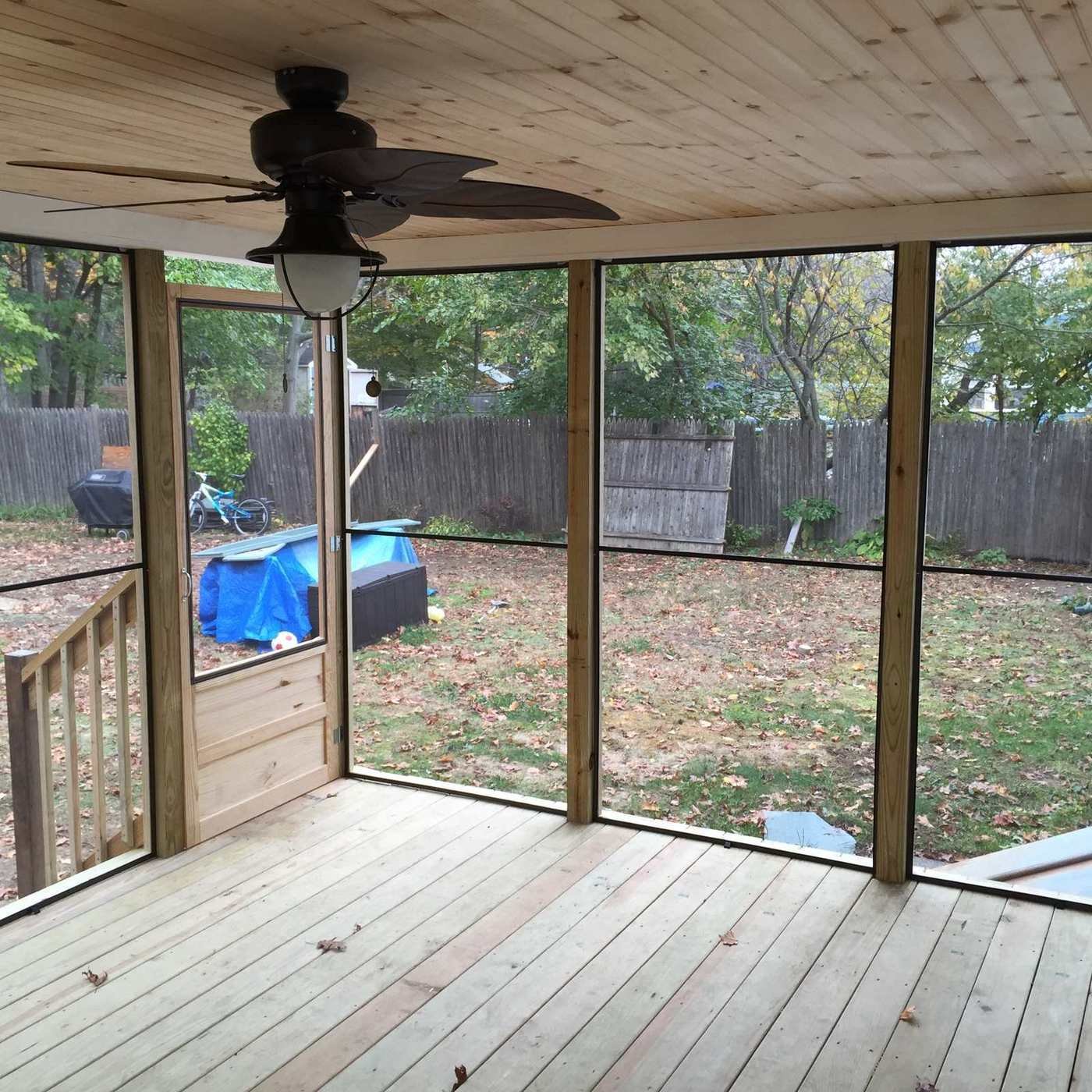 Screened porch interior with wood ceiling and fan