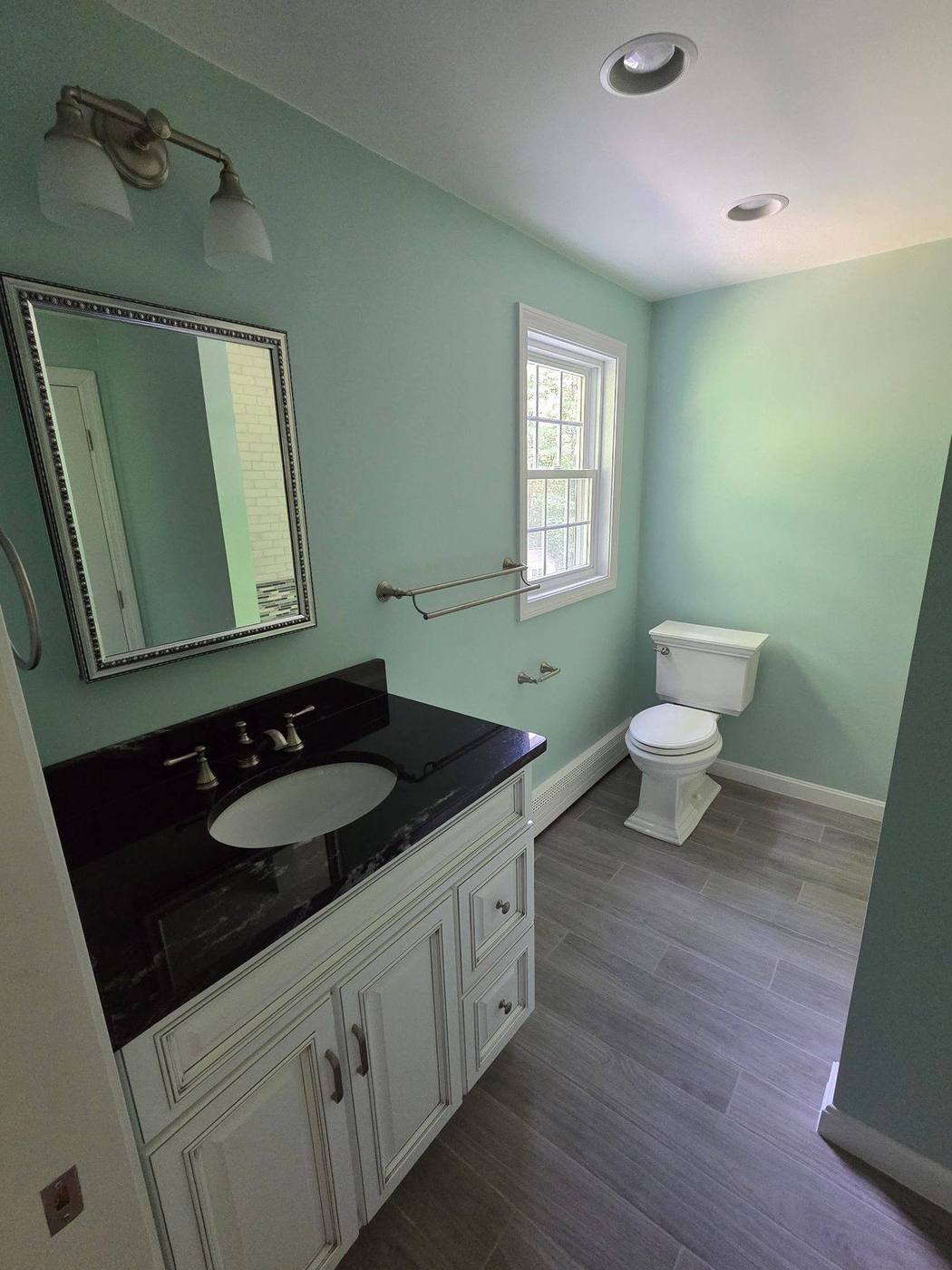 New vanity with granite top, new mirror, lighting and floor