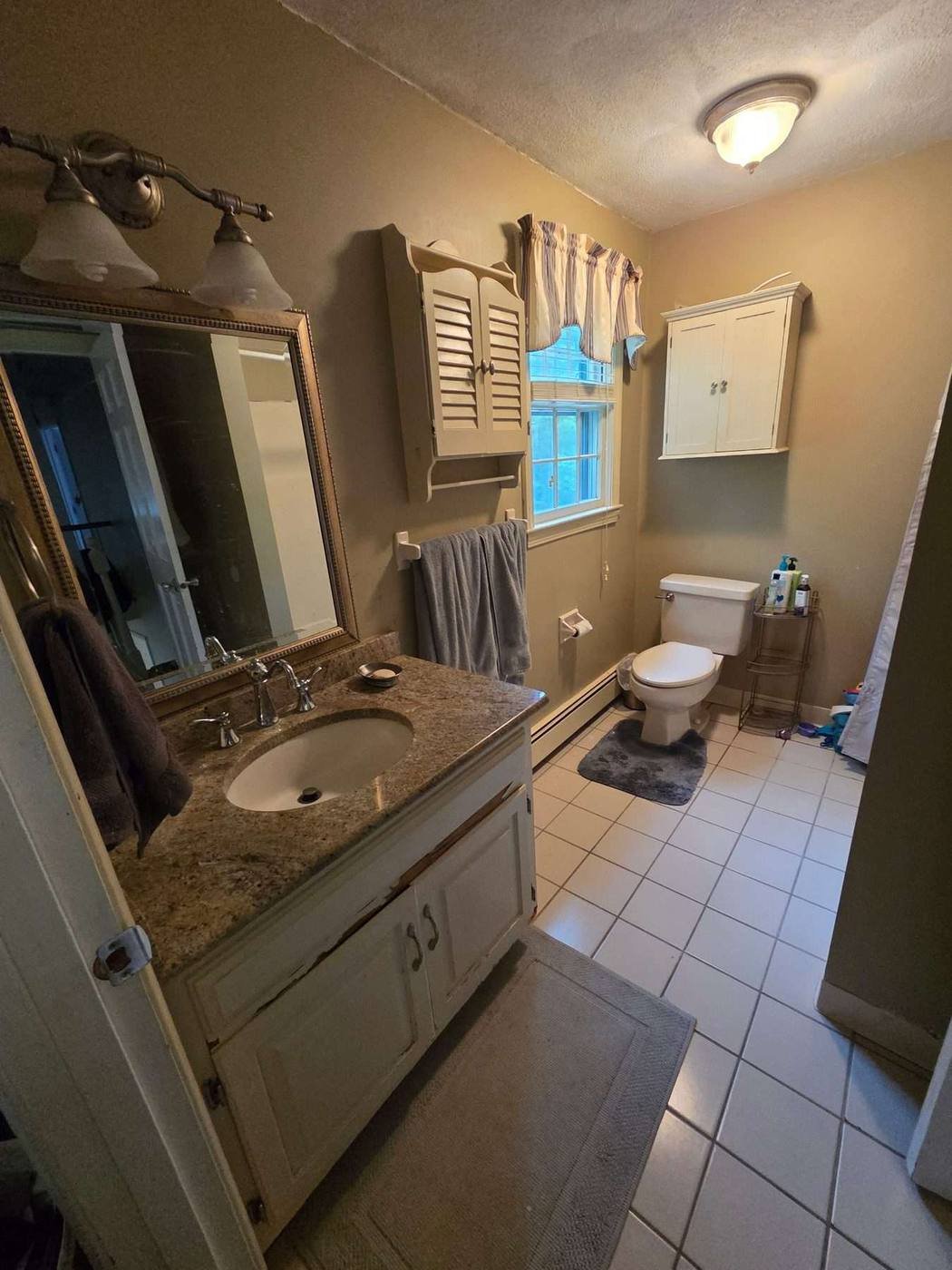 Dated bathroom vanity and floor before remodel
