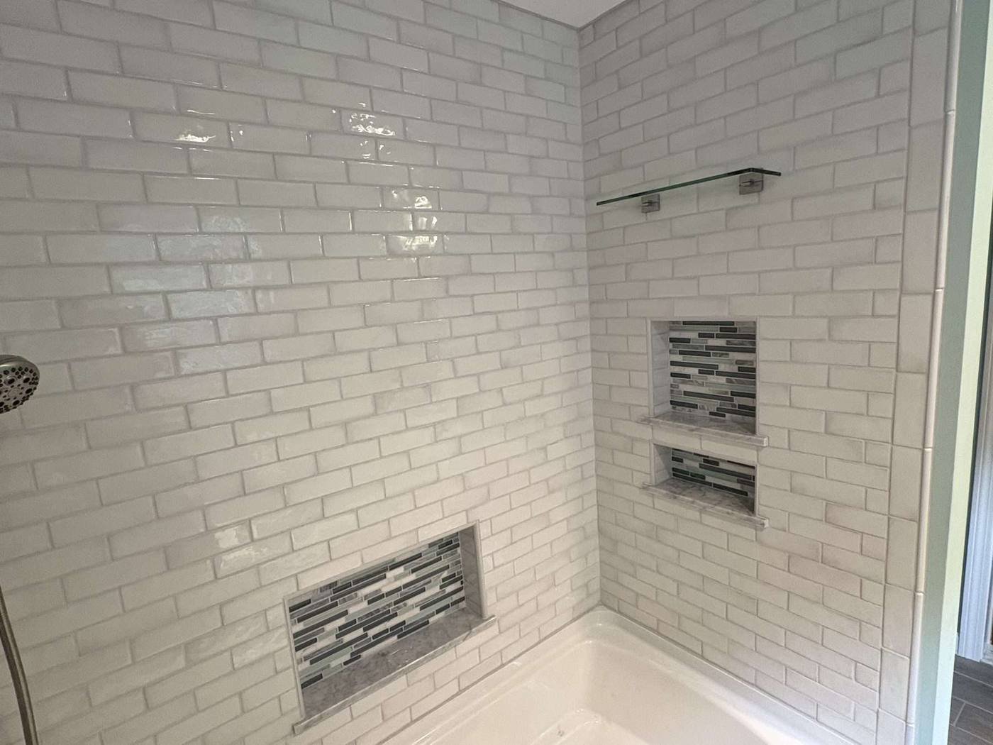 Two mosaic niches in a subway tiled shower