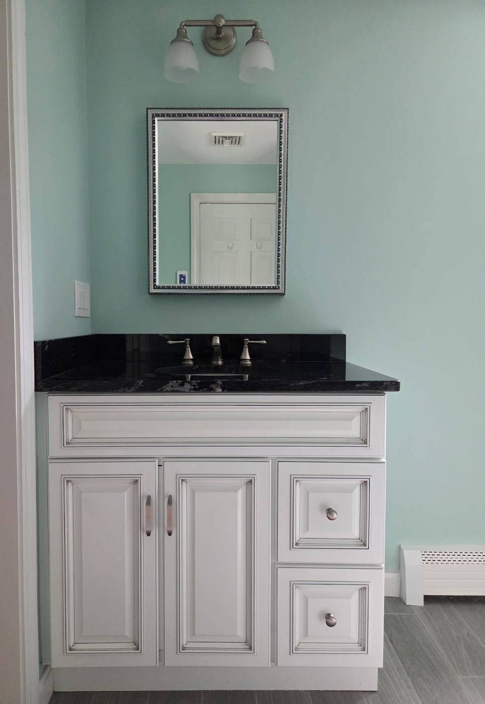 Vanity with granite top and framed mirror